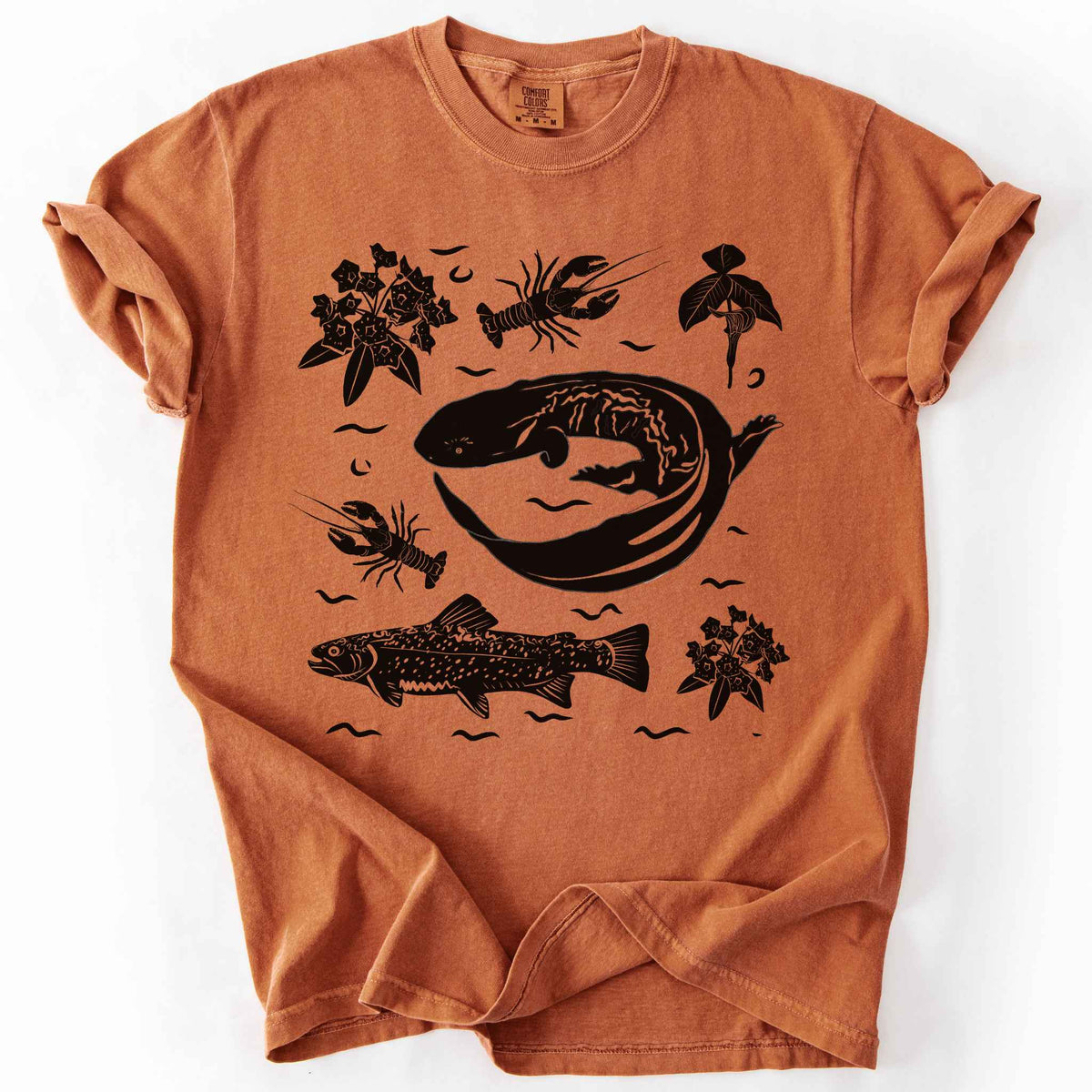 Yam "Hellbender Ecology" t-shirt on Comfort Colors tee, featuring a curled hellbender salamander surrounded by hand-drawn crayfish, trout, and mountain laurel. Amphibian and river ecosystem gift shirt for herpetology and fly fishing enthusiasts.
